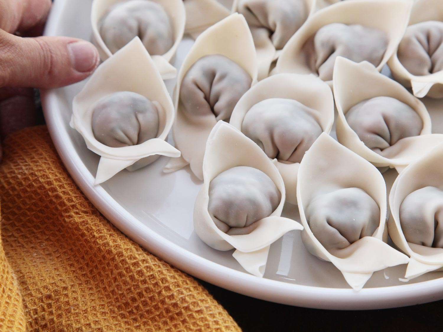 Transferring finished wontons onto a plate