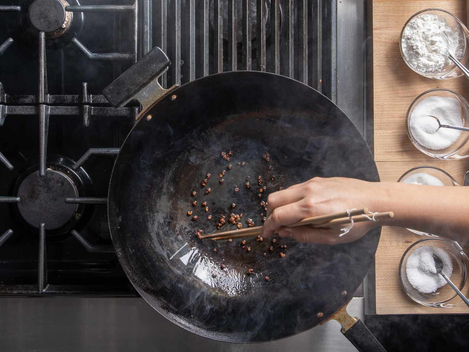 Sichuan peppercorns toasting in a smoky wok.