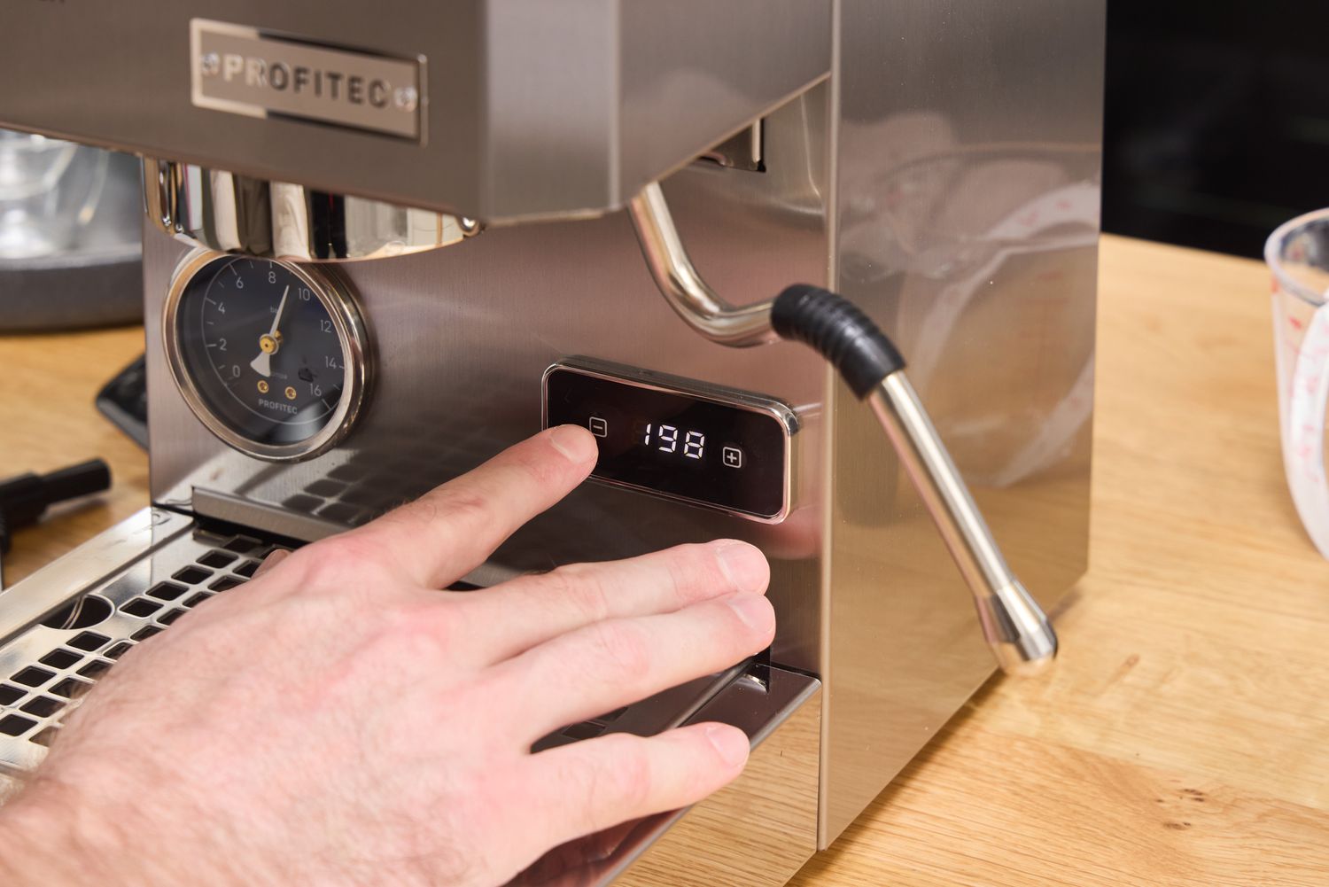 A person presses a button on the Profitec GO Single Boiler Espresso Machine