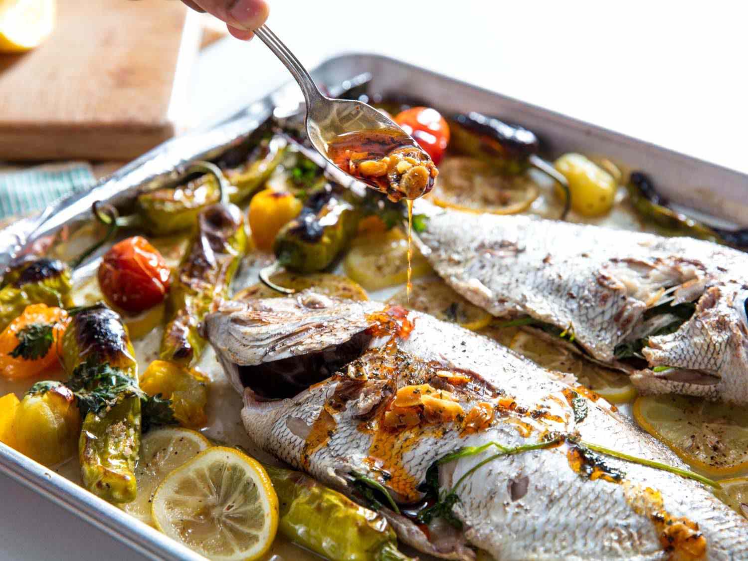 Finishing whole broiled porgy with garlic and chili oil