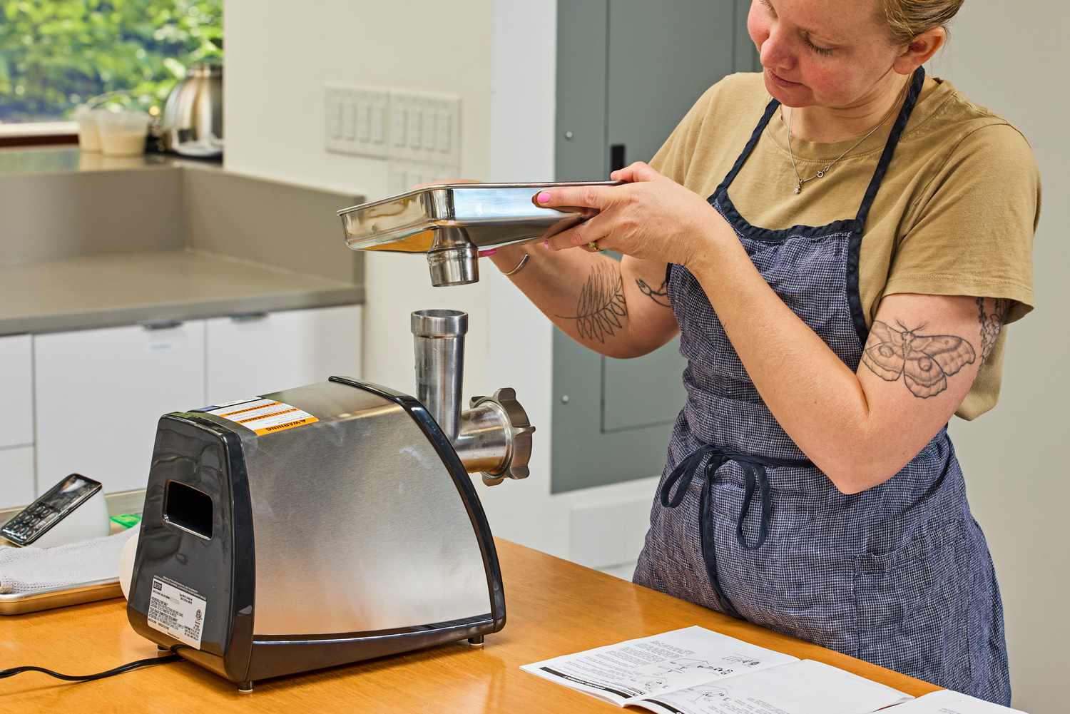 Person fixing food tray to Weston #8 Electric Meat Grinder