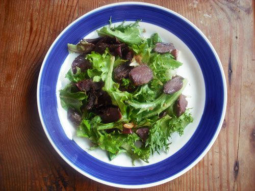 cooked gizzards plated over a green salad