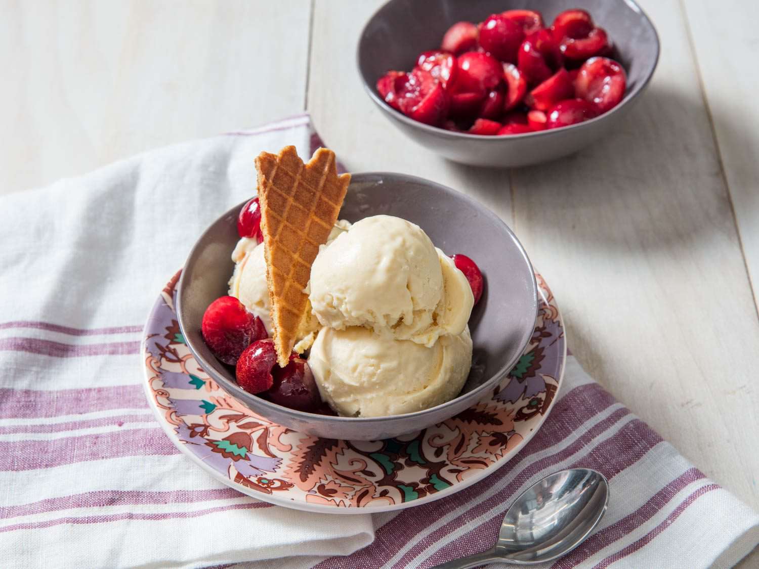 A three-scoop serving of no-churn mascarpone ice cream with macerated cherries and waffle cone tuille.
