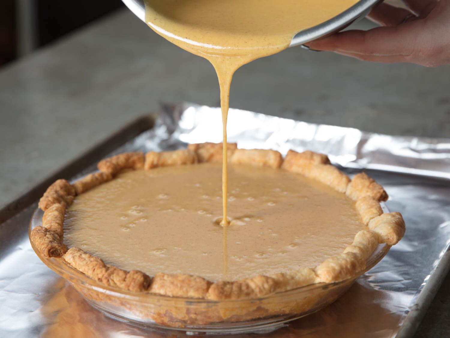 Adding squash pie filling to a fully baked crust.
