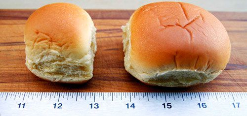 Two buns on a table, placed next to a ruler.