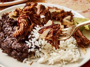 A plate of shredded beef with rice and black beans