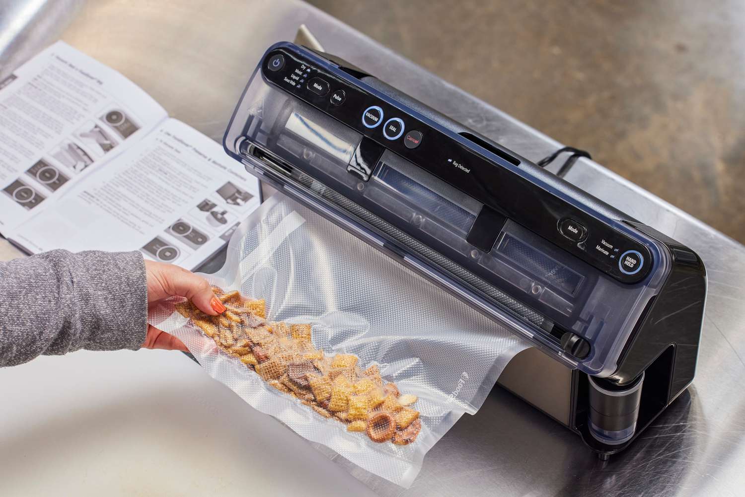 A person vacuum seals Chex Mix in the FoodSaver VS5960 Elite All-in-One Liquid+ Vacuum Sealer
