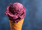 A scoop of no-churn blueberry ice cream on a waffle cone.