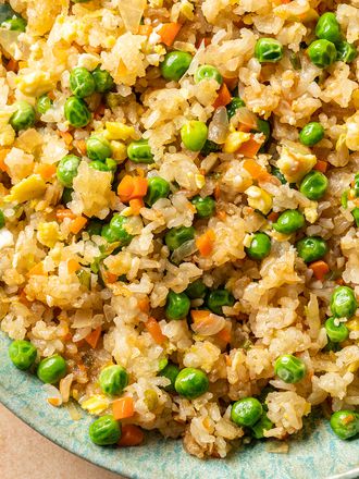 Vegetable fried rice inside a green ceramic bowl.