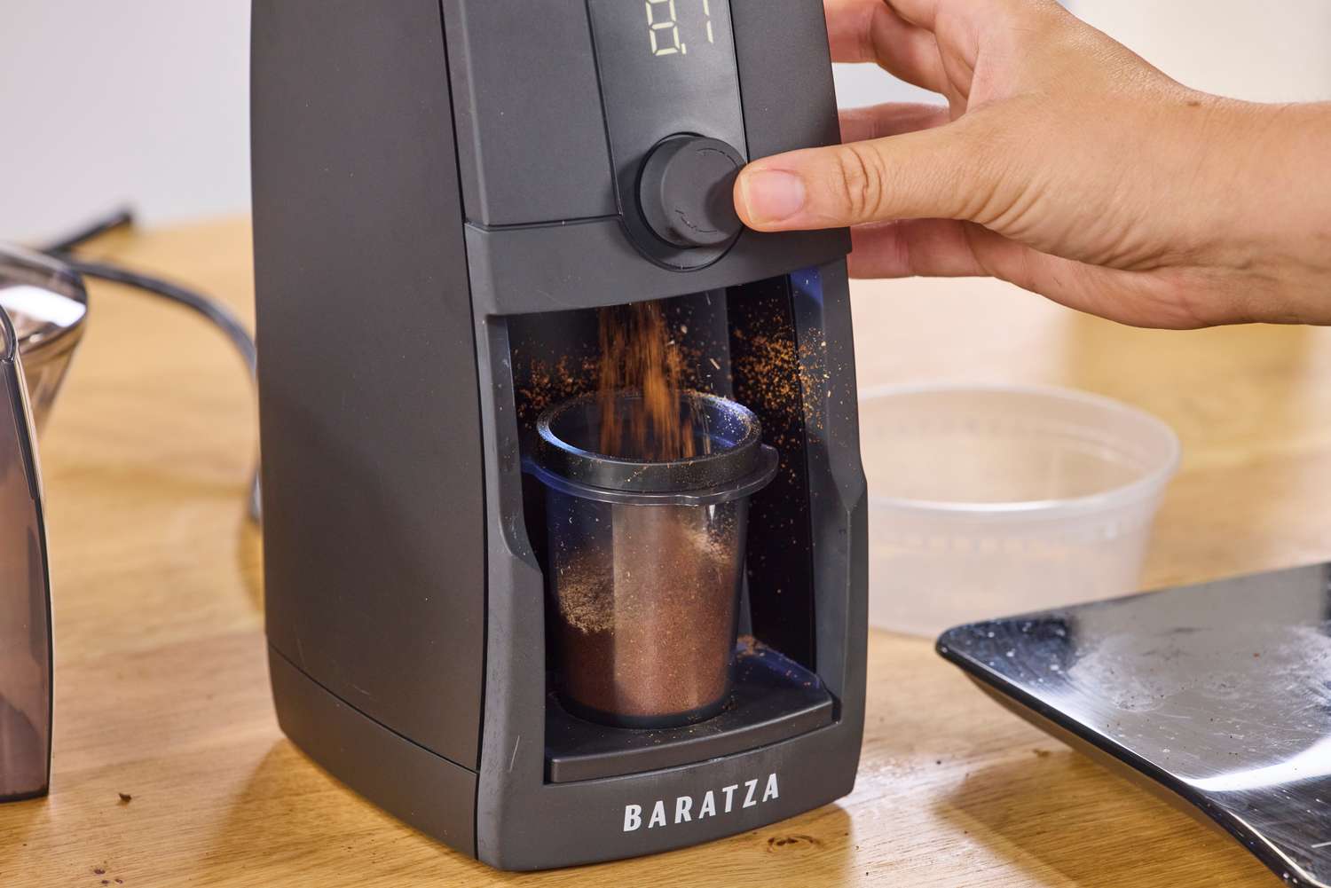 A person presses a button on the Baratza Encore ESP Pro Coffee Grinder