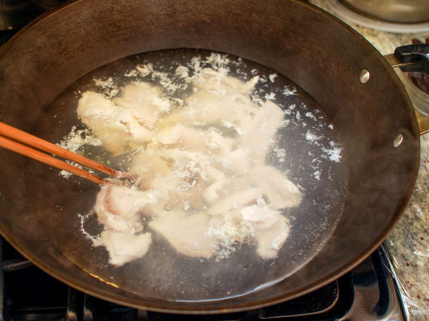 Marinated chicken is briefly cooked in the boiling water.