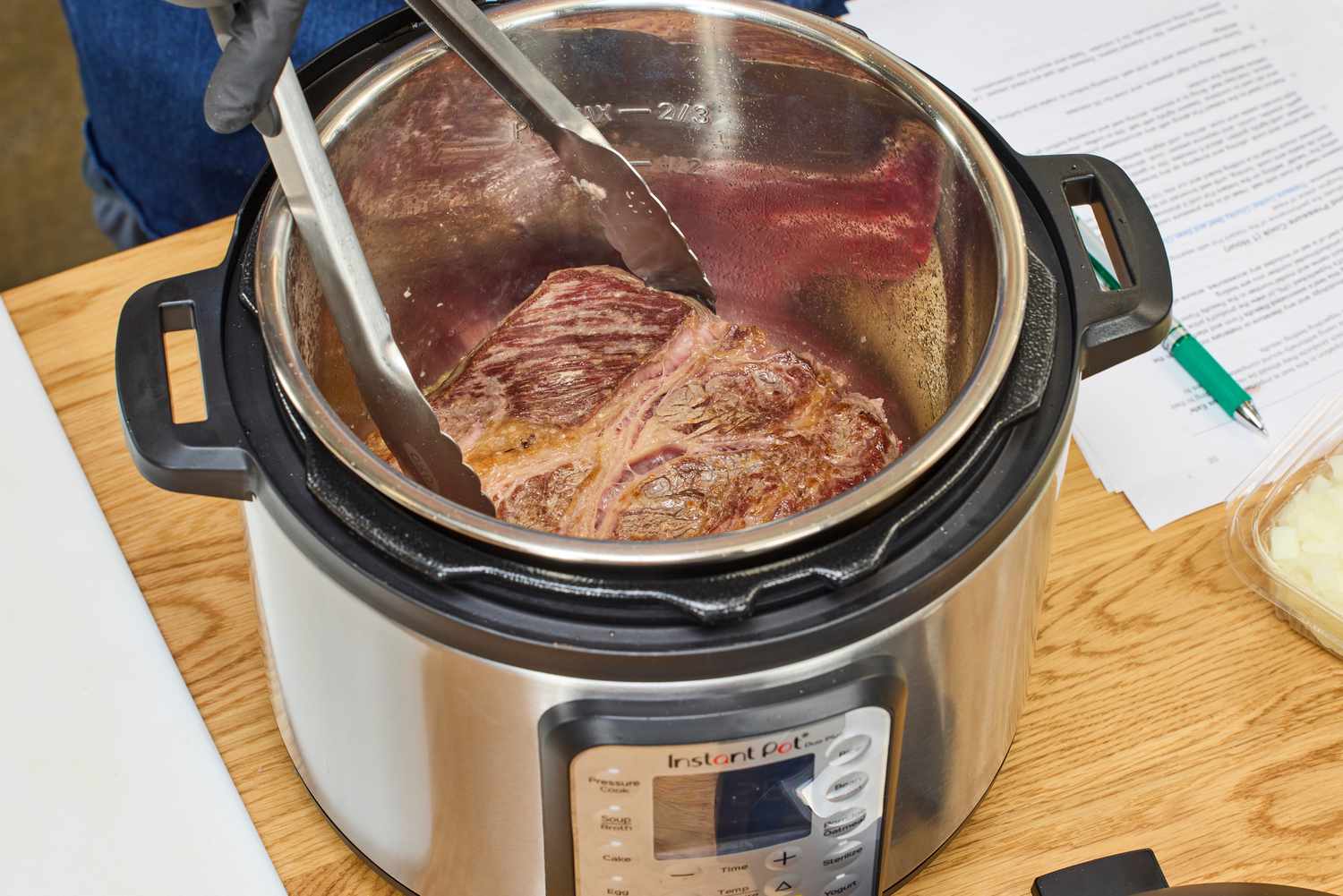 A piece of meat is placed in the Instant Pot Duo Plus 6-Quart 9-in-1 Pressure Cooker