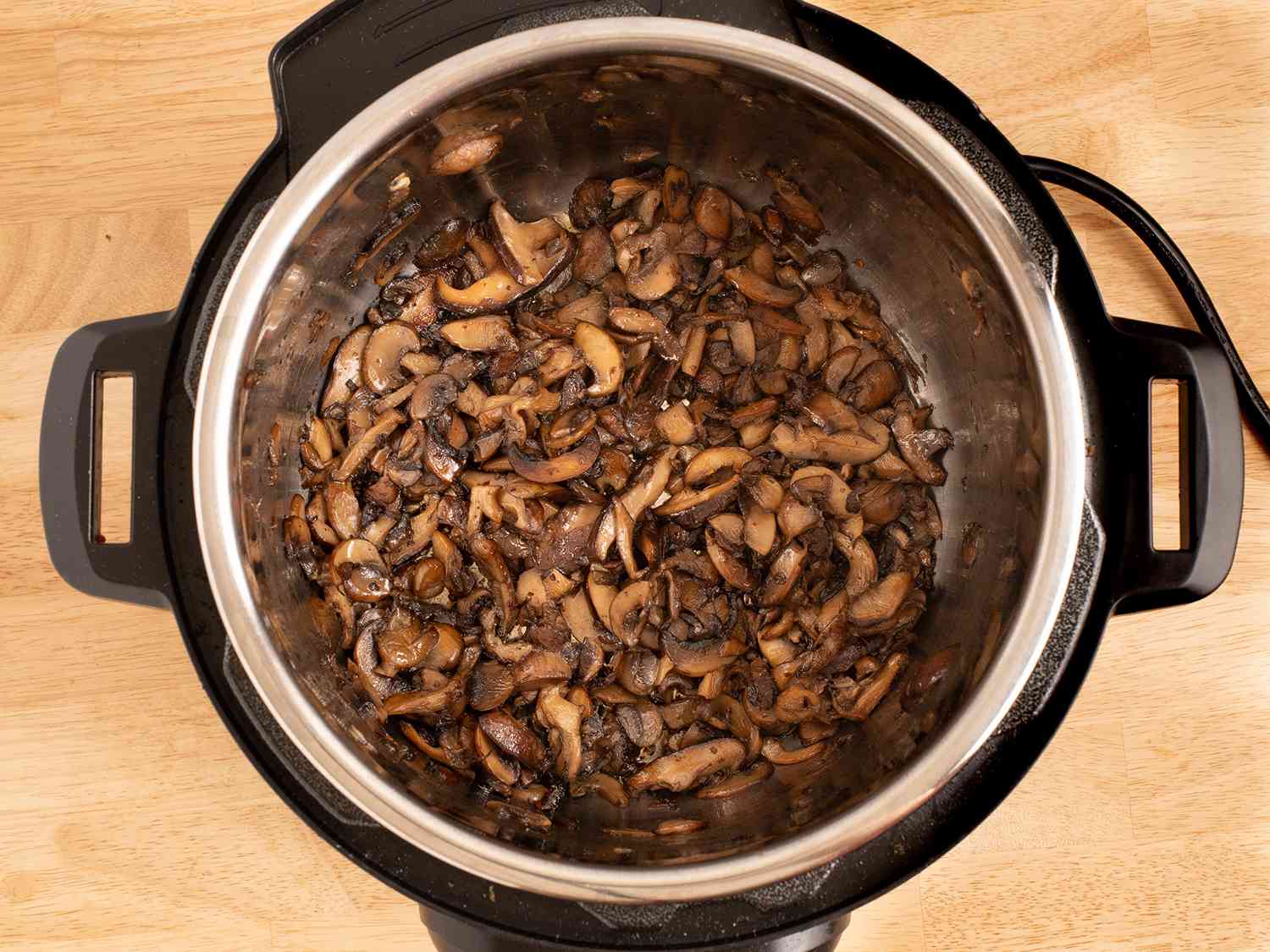 The browned mushrooms inside of the pressure cooker.