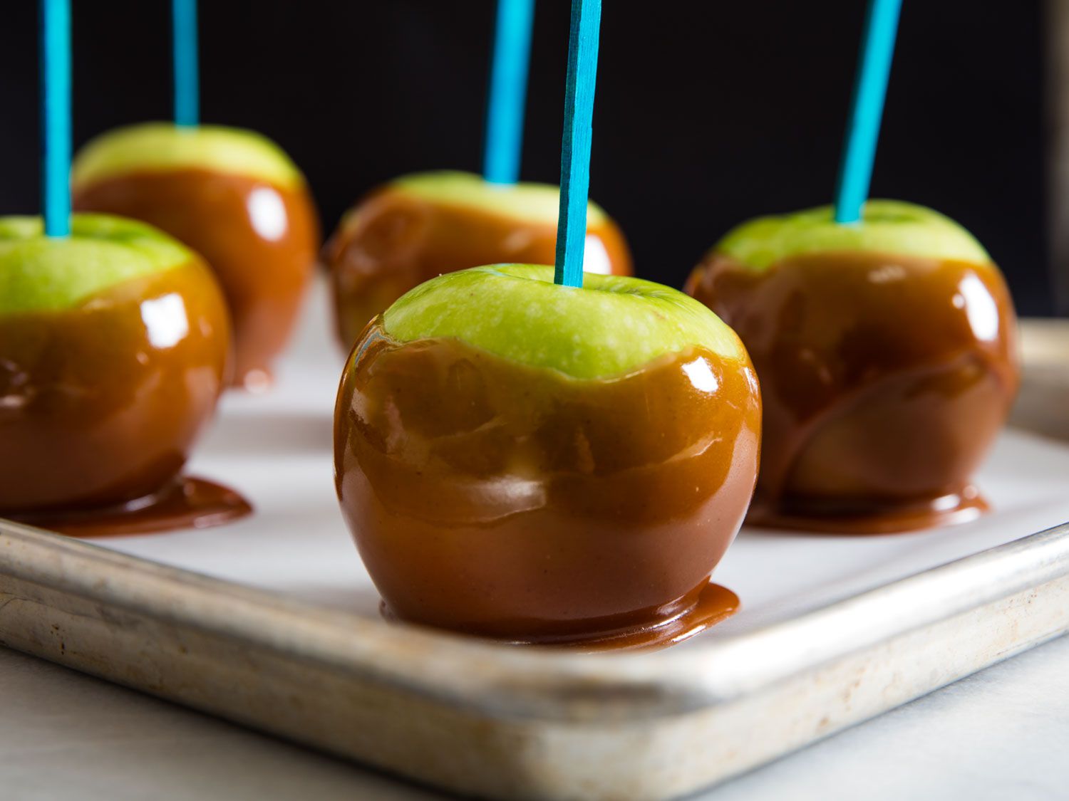 Caramel-dipped green apples on a stick 