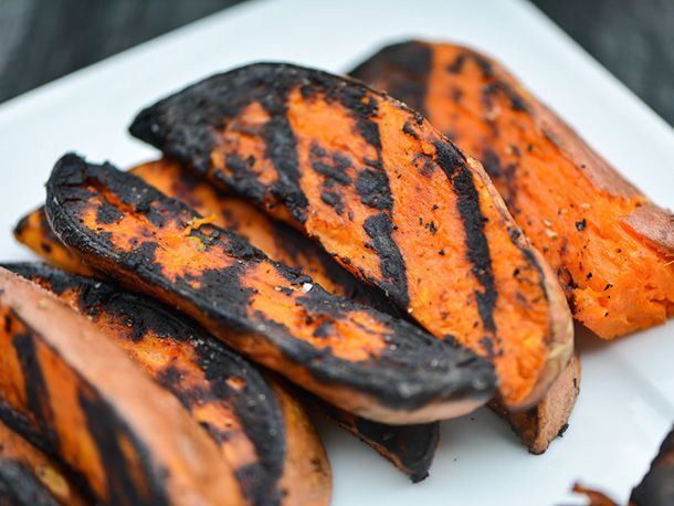 Sweet potato wedges looking charred on a serving plate. 