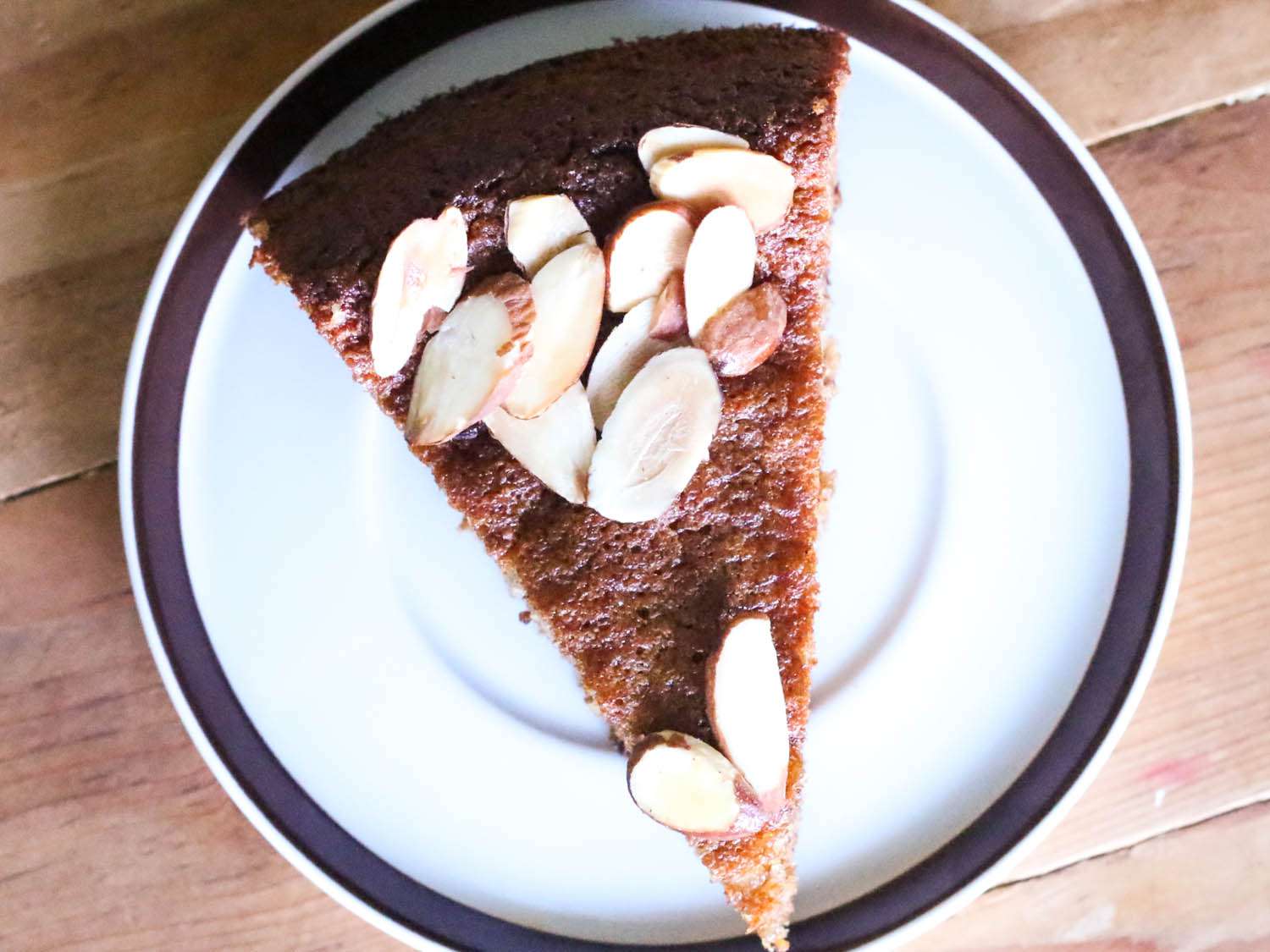 A top-down shot of a slice of almond cake on a plate.