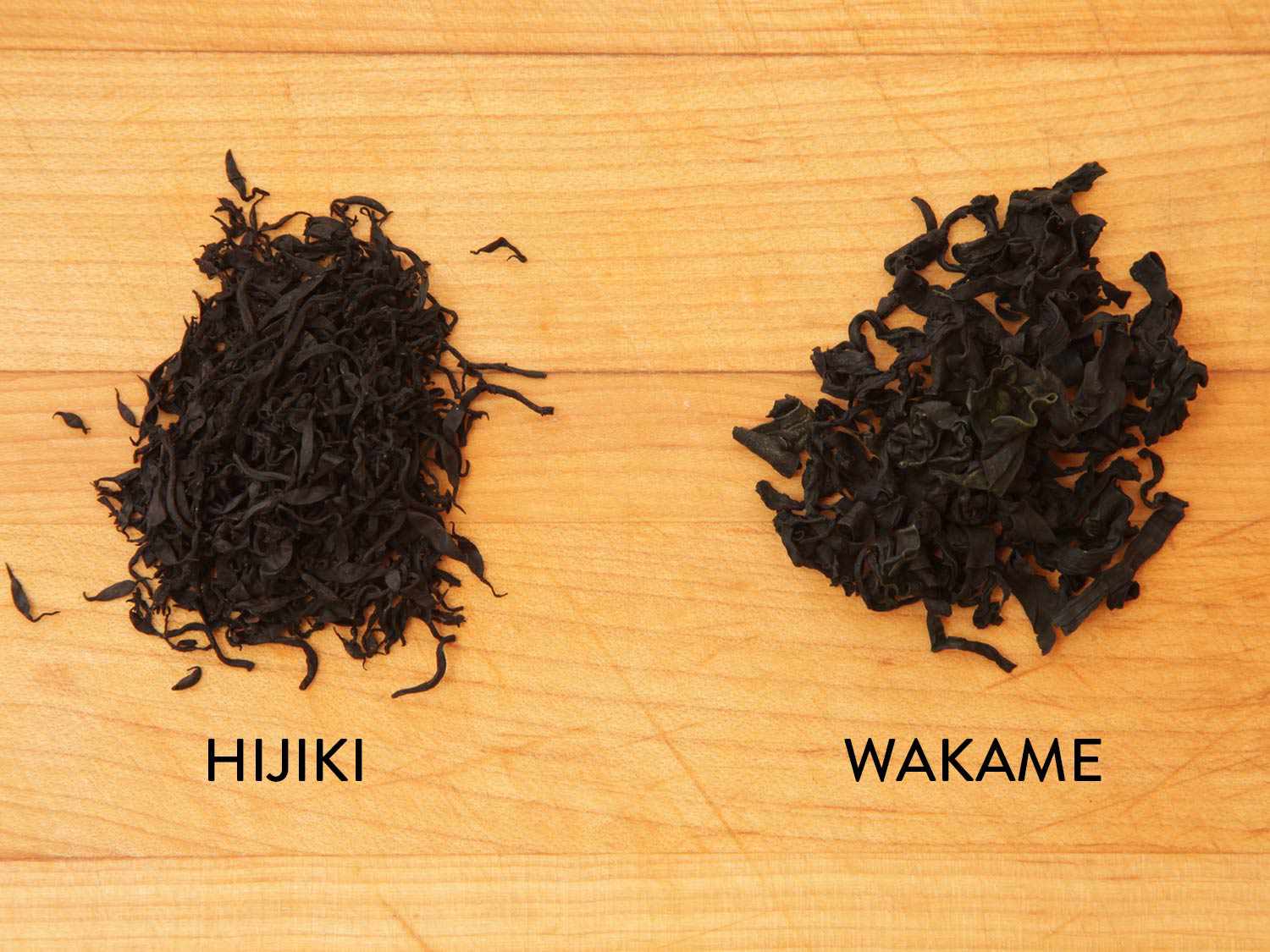 Two piles of chopped seaweed with the words, "hijiki" under the left pile and "wakame" under the right pile.