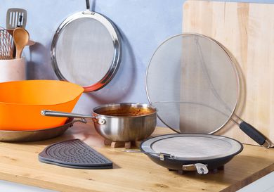 a variety of splatter screens with a pot full of tomato sauce