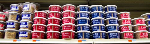 Different varieties of pork floss stacked on a shelf.