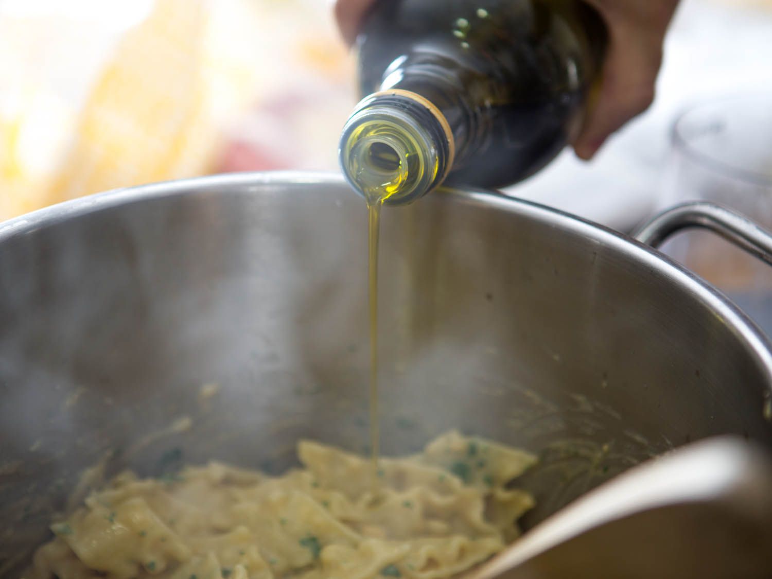 Olive oil is drizzled and tossed with the chickpea pasta.