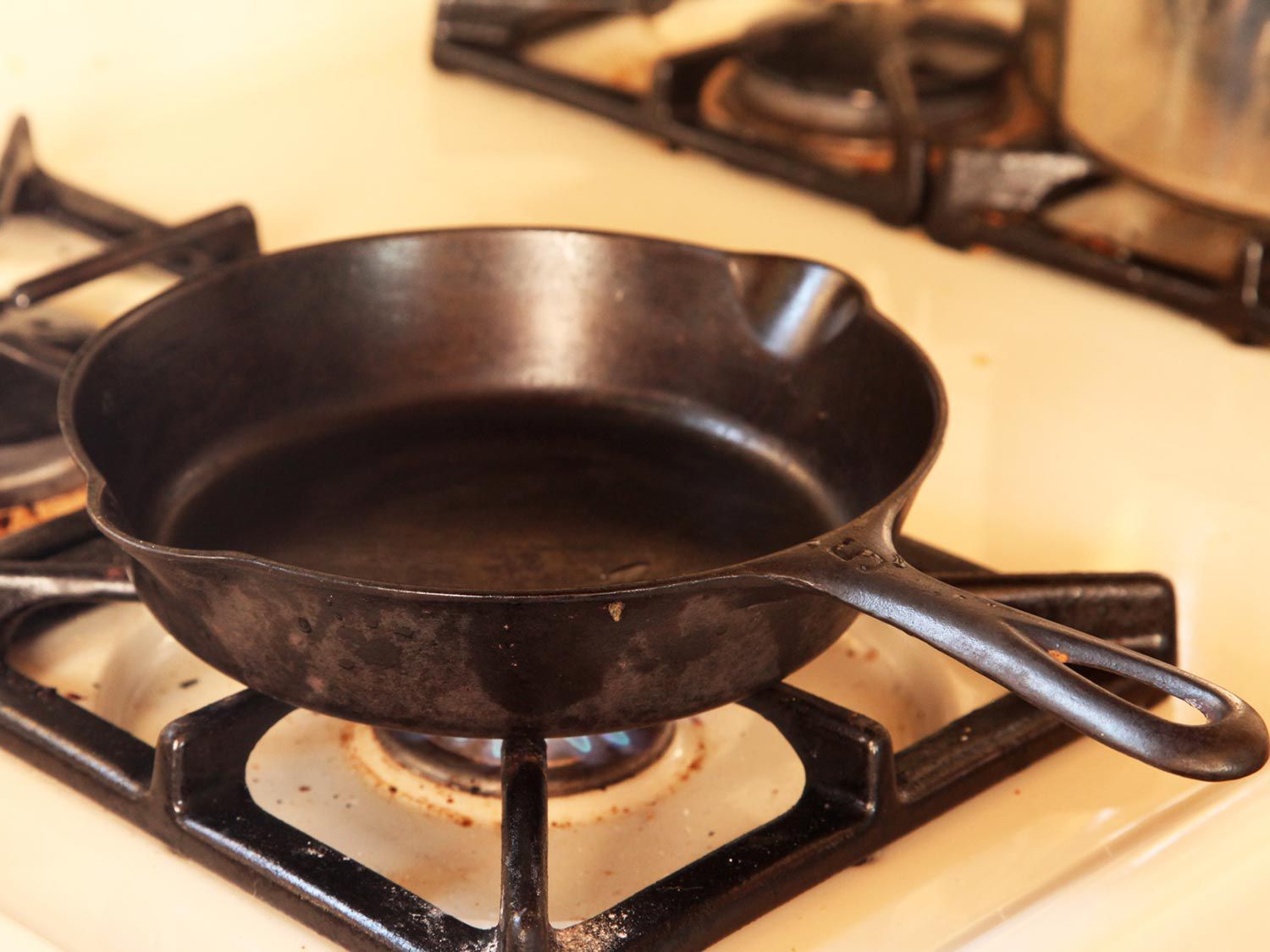 Heating a cast iron skillet on a gas stovetop