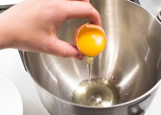 Separating the white from yolk. The white is dropped into a mixing bowl. 