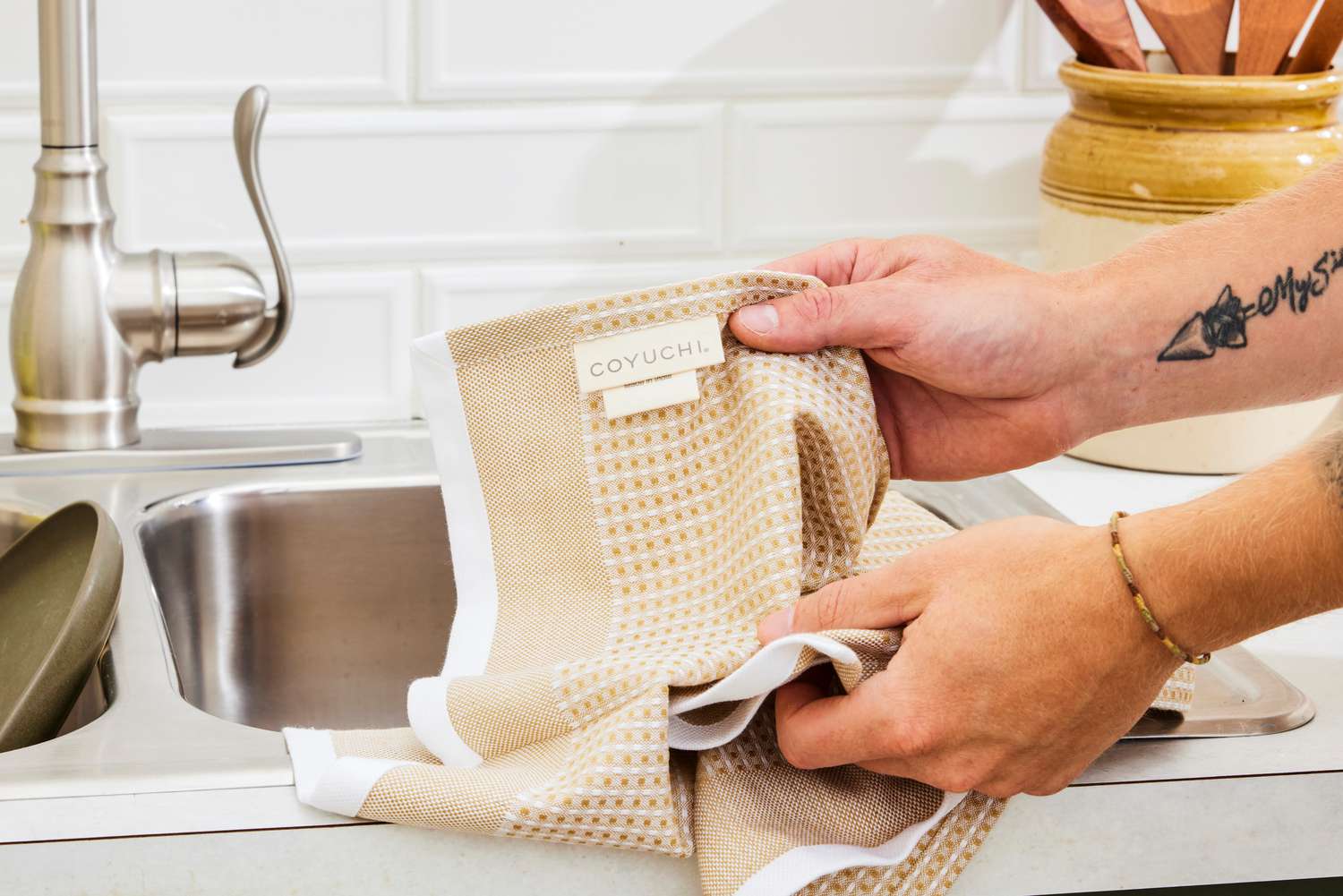 A person holding up a Coyuchi dish towel.