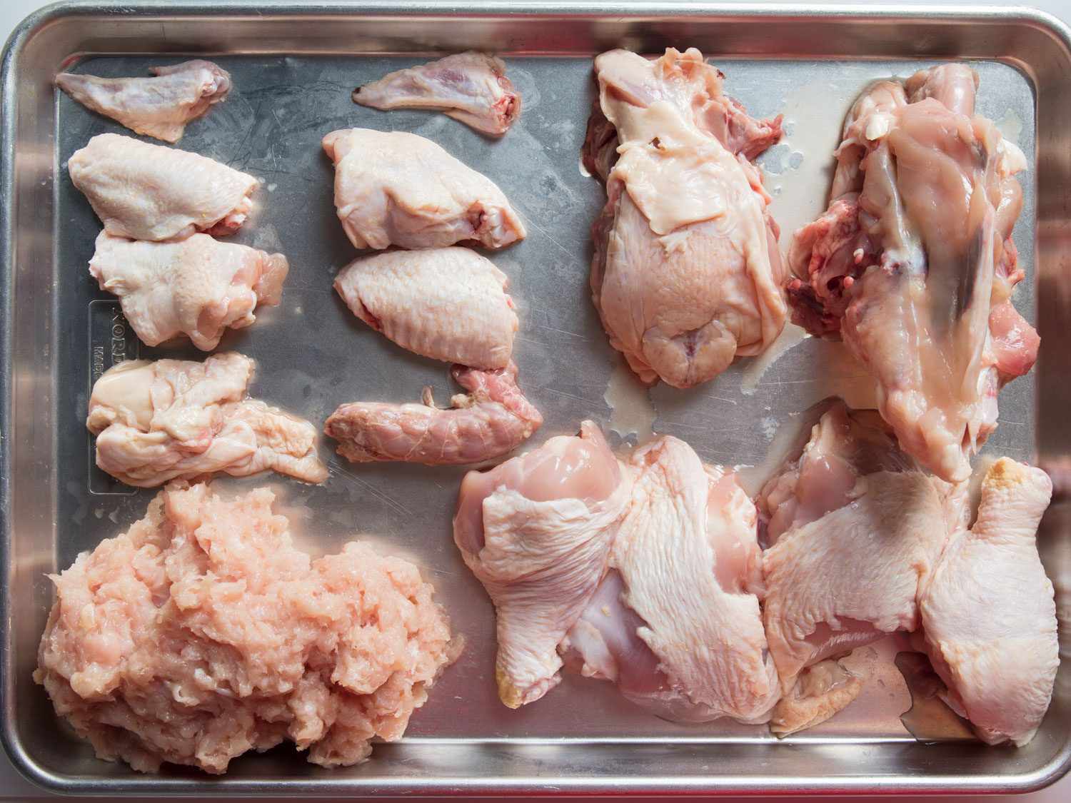 Overhead view of chicken cut into parts with ground breast meat for chintan ramen broth.