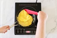 Scrambled eggs cooking in a pan on the Duxtop 9100 portable induction burner.