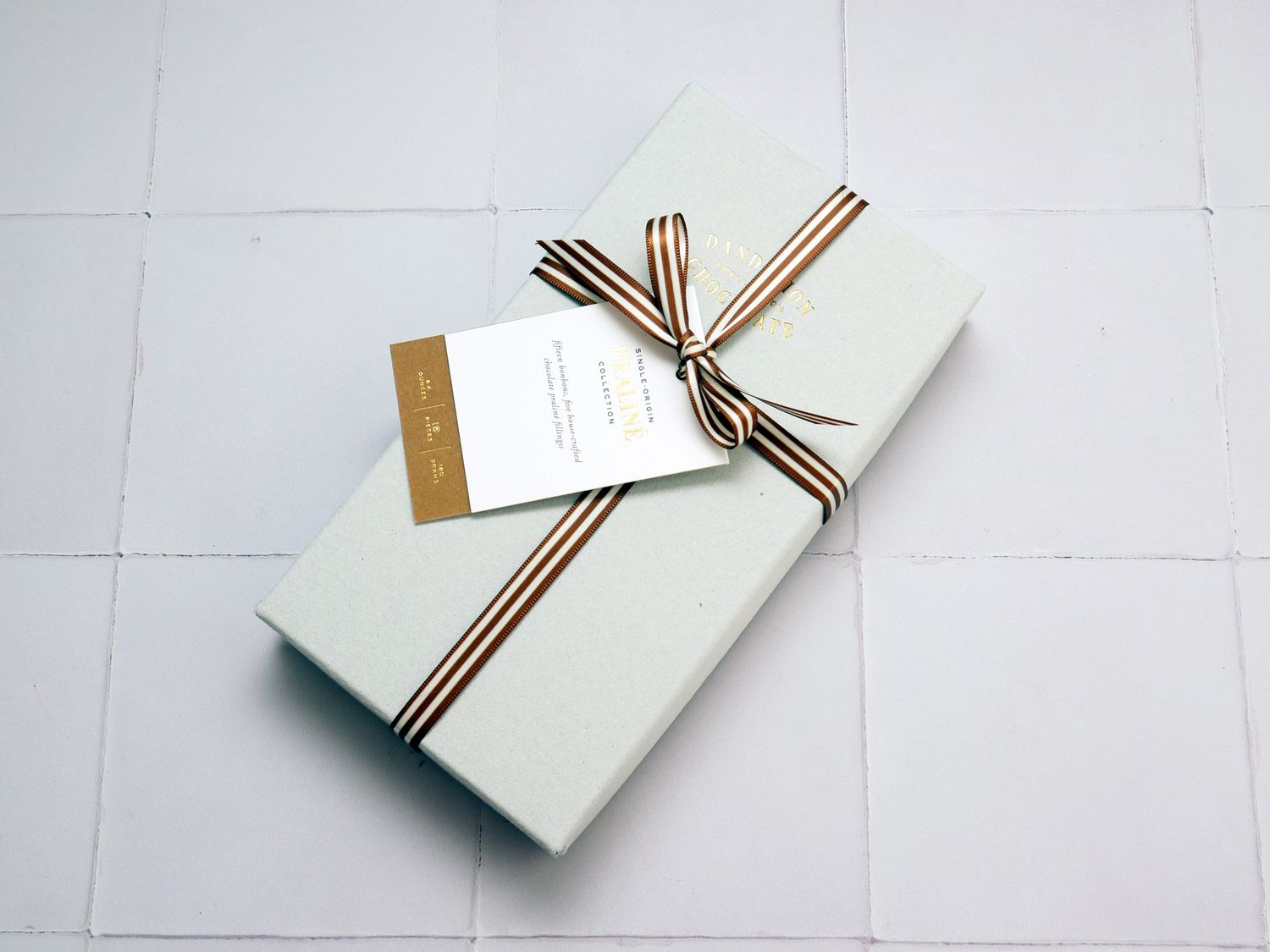 box of chocolates on a white tile surface