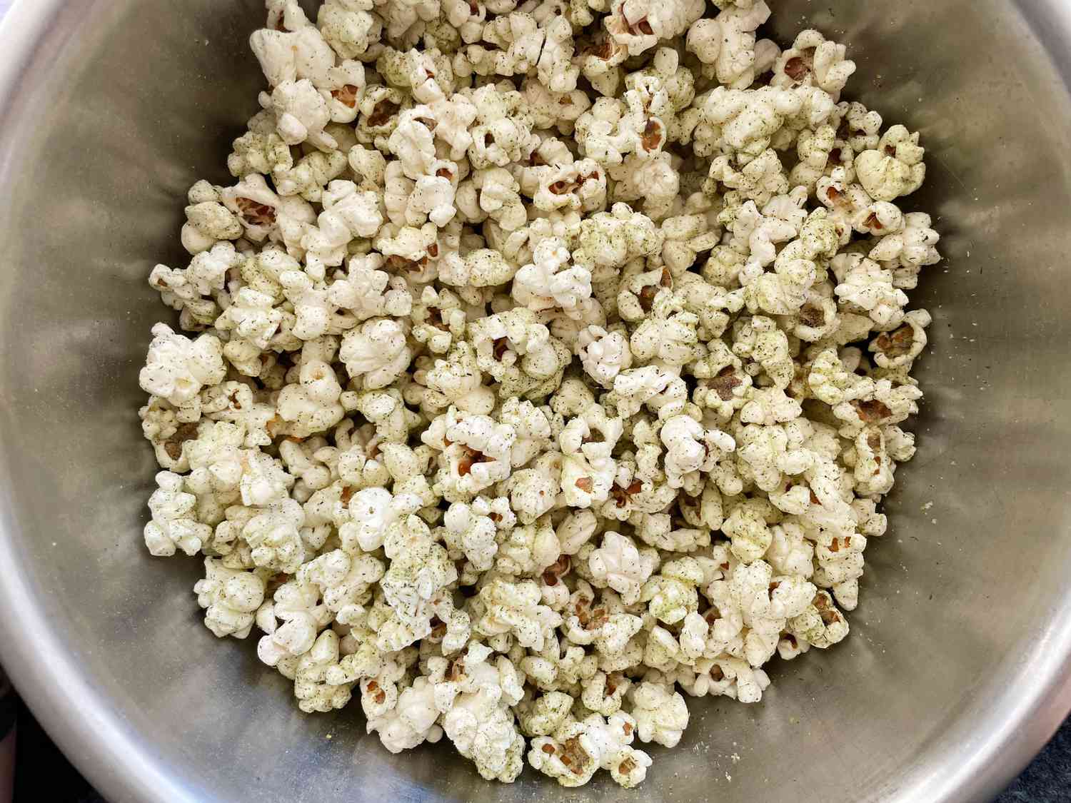 A bowl of popcorn with ranch seasoning. 