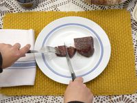 a person using the zwilling porterhouse steak knife to slice steak
