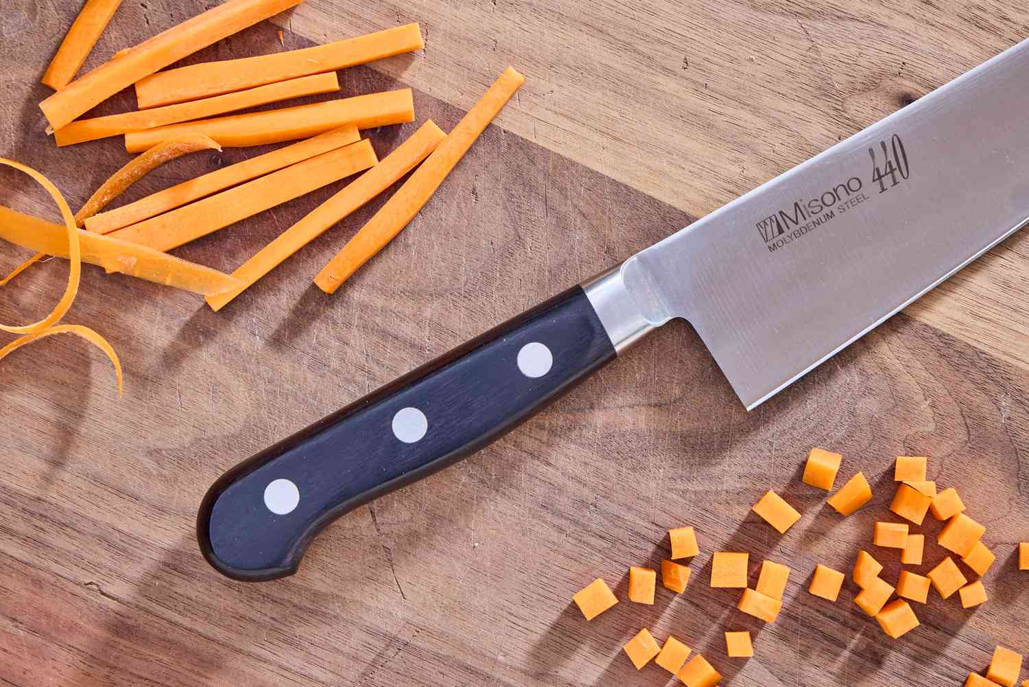 The Misono 8.2 Inch Molybdenum Gyutou beside pieces of chopped carrot on a wooden cutting board