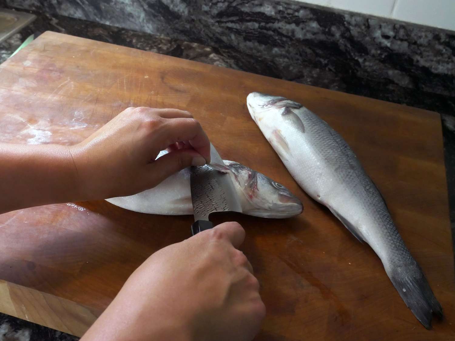 using a deba to cut the fit off a small sea bass