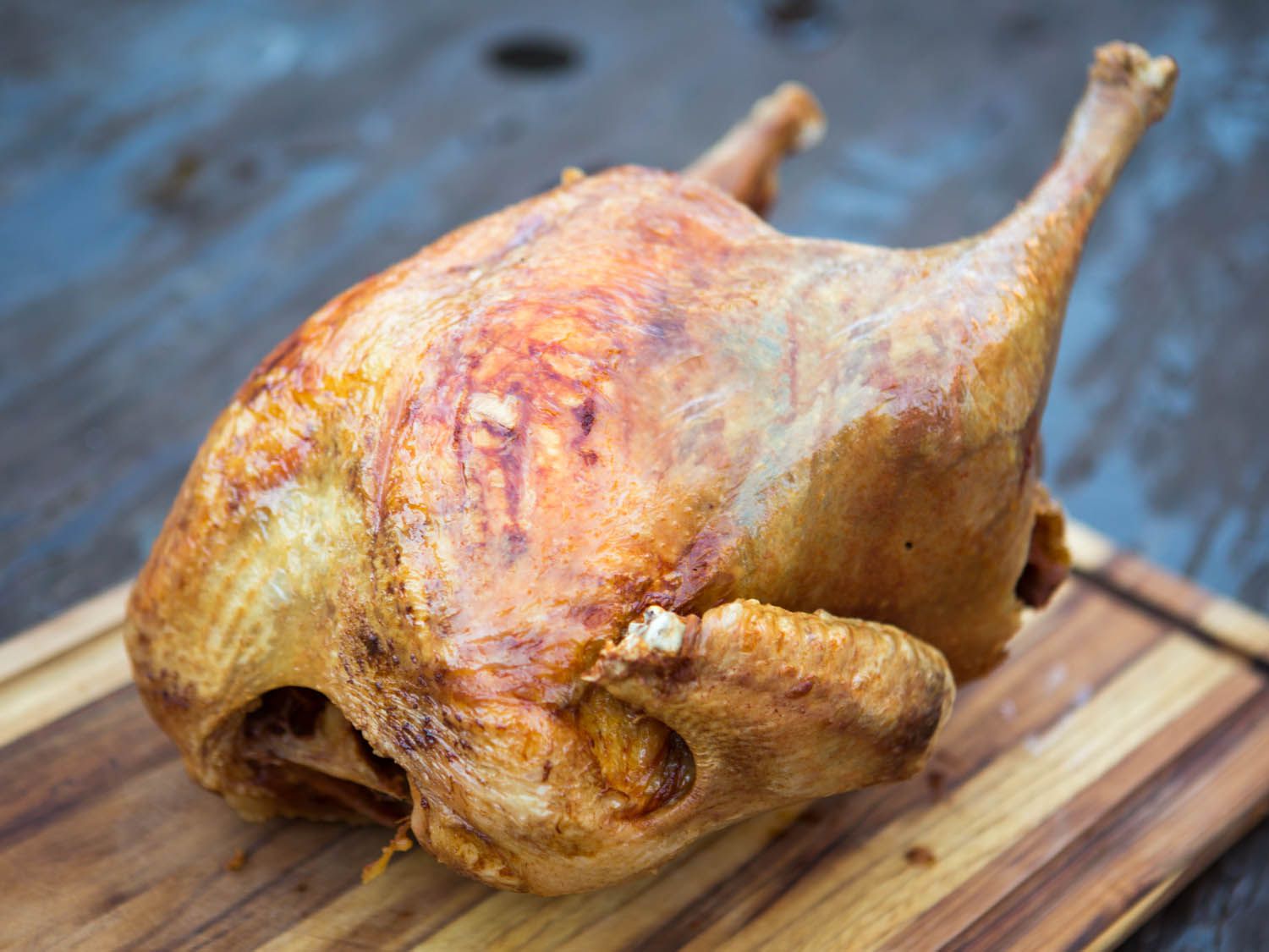 A whole deep fried turkey on a cutting board.