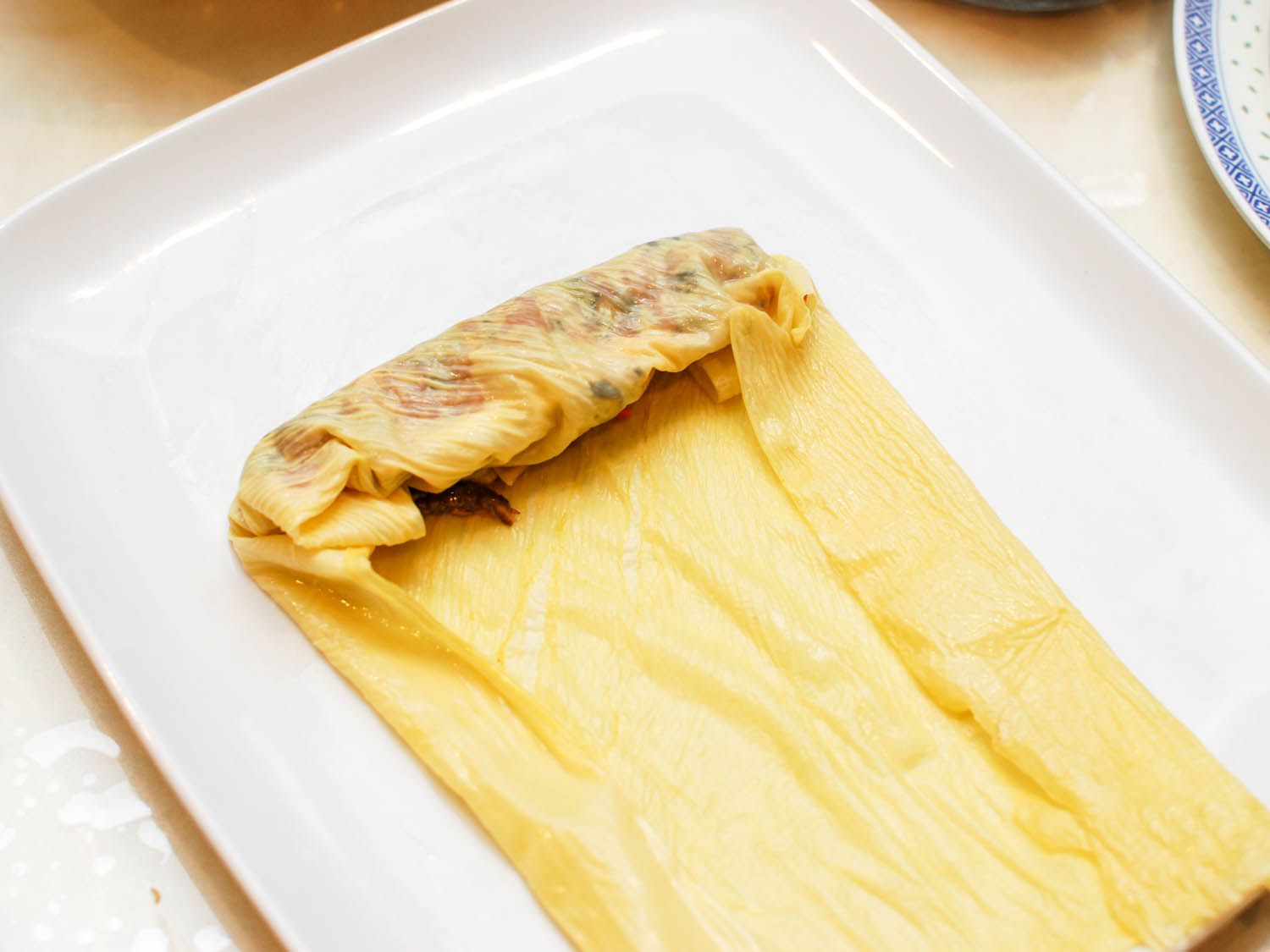 Bean curd sheet is stuffed and ready to be rolled.