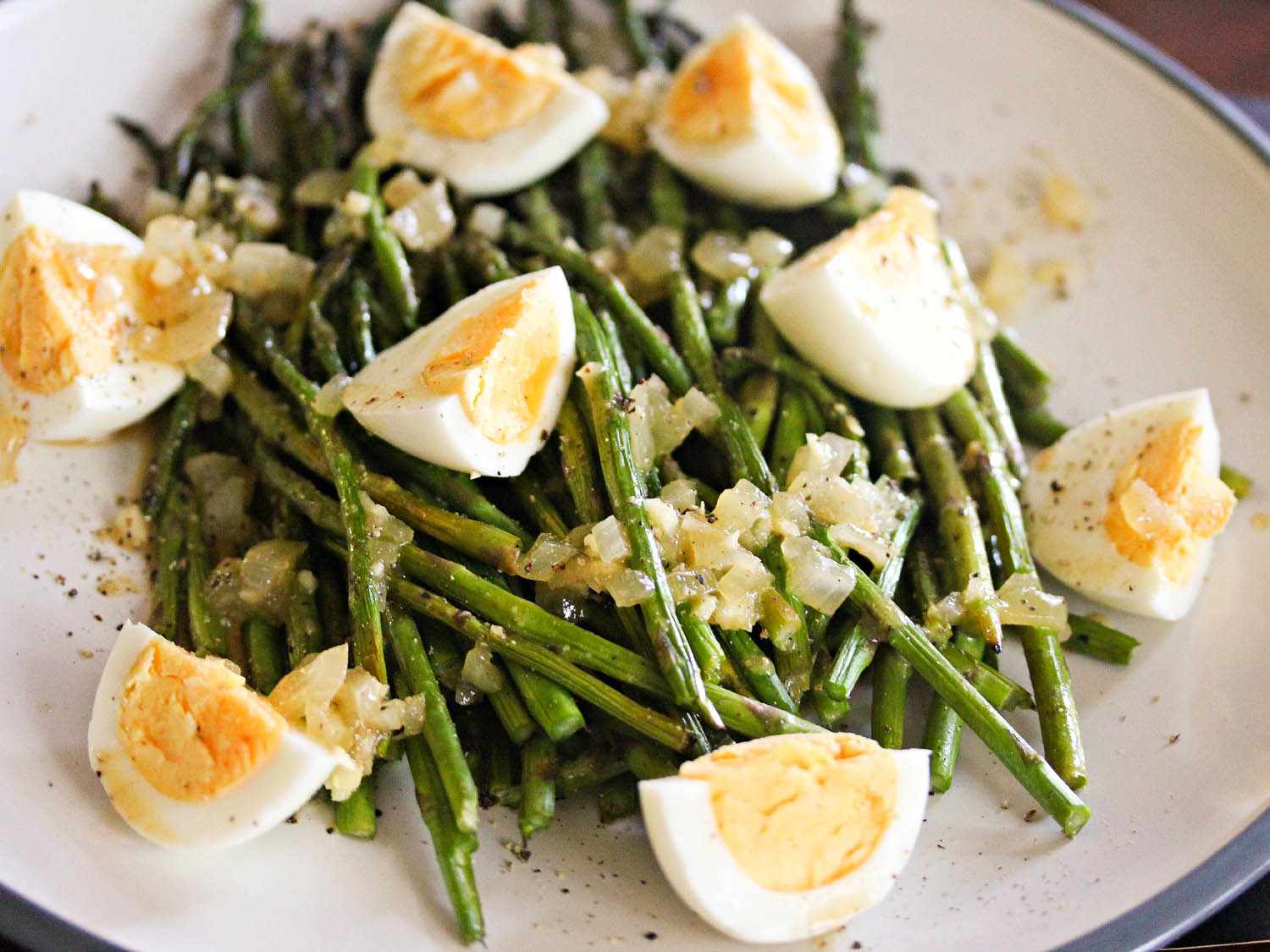 A plate of grilled asparagus with hard-boiled eggs