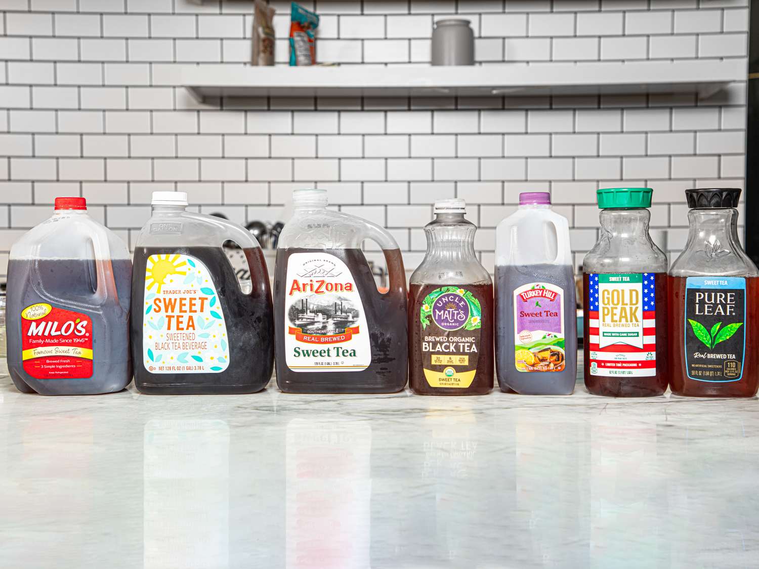 Various branded sweet tea bottles lined up on a counter