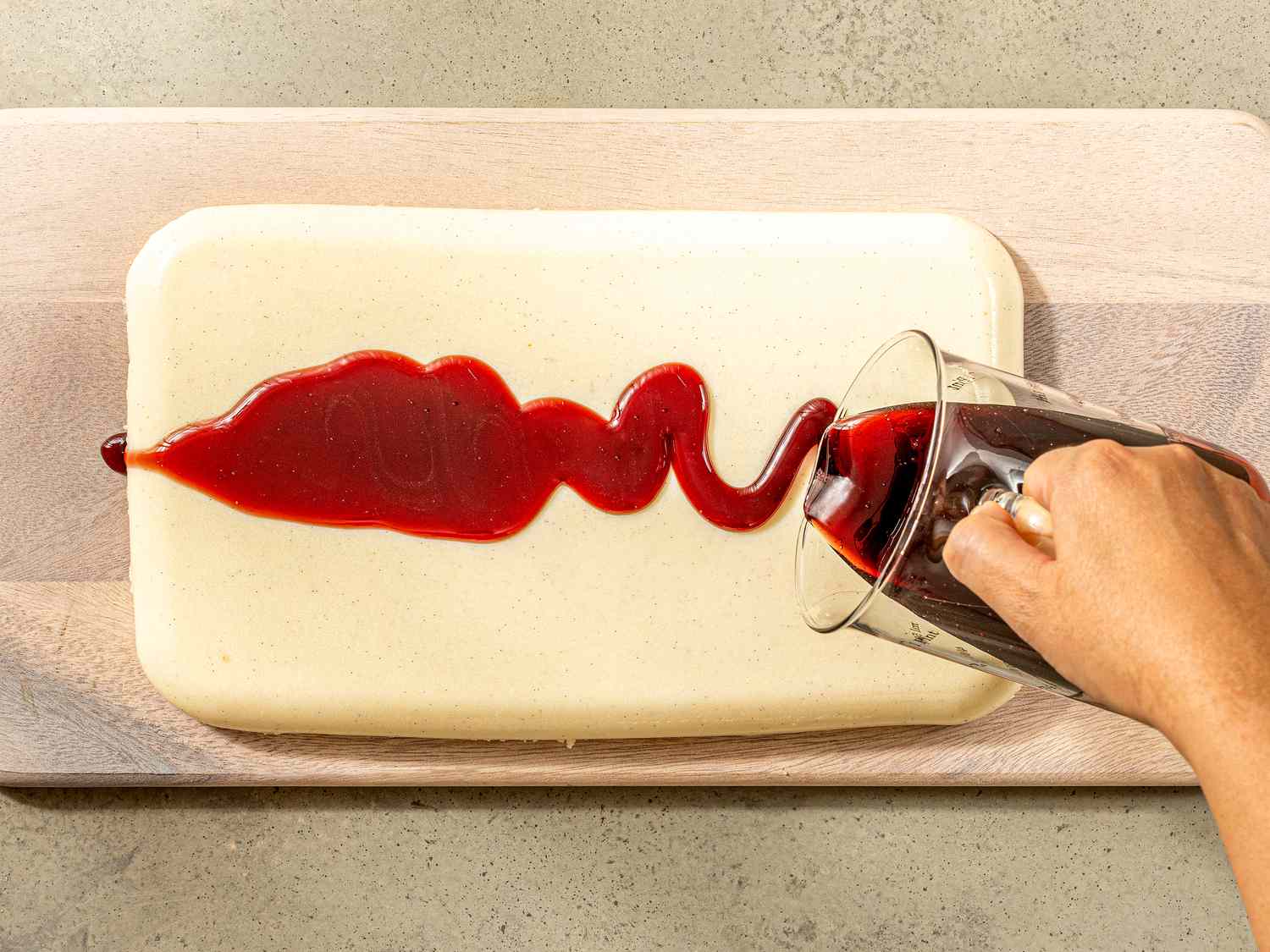 Overhead view of pouring wine syrup onto pudding.