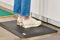 A person stands on the ComfiLife Anti-Fatigue Floor Mat