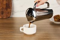 Person pouring coffee into cup with Espro P7 French Press