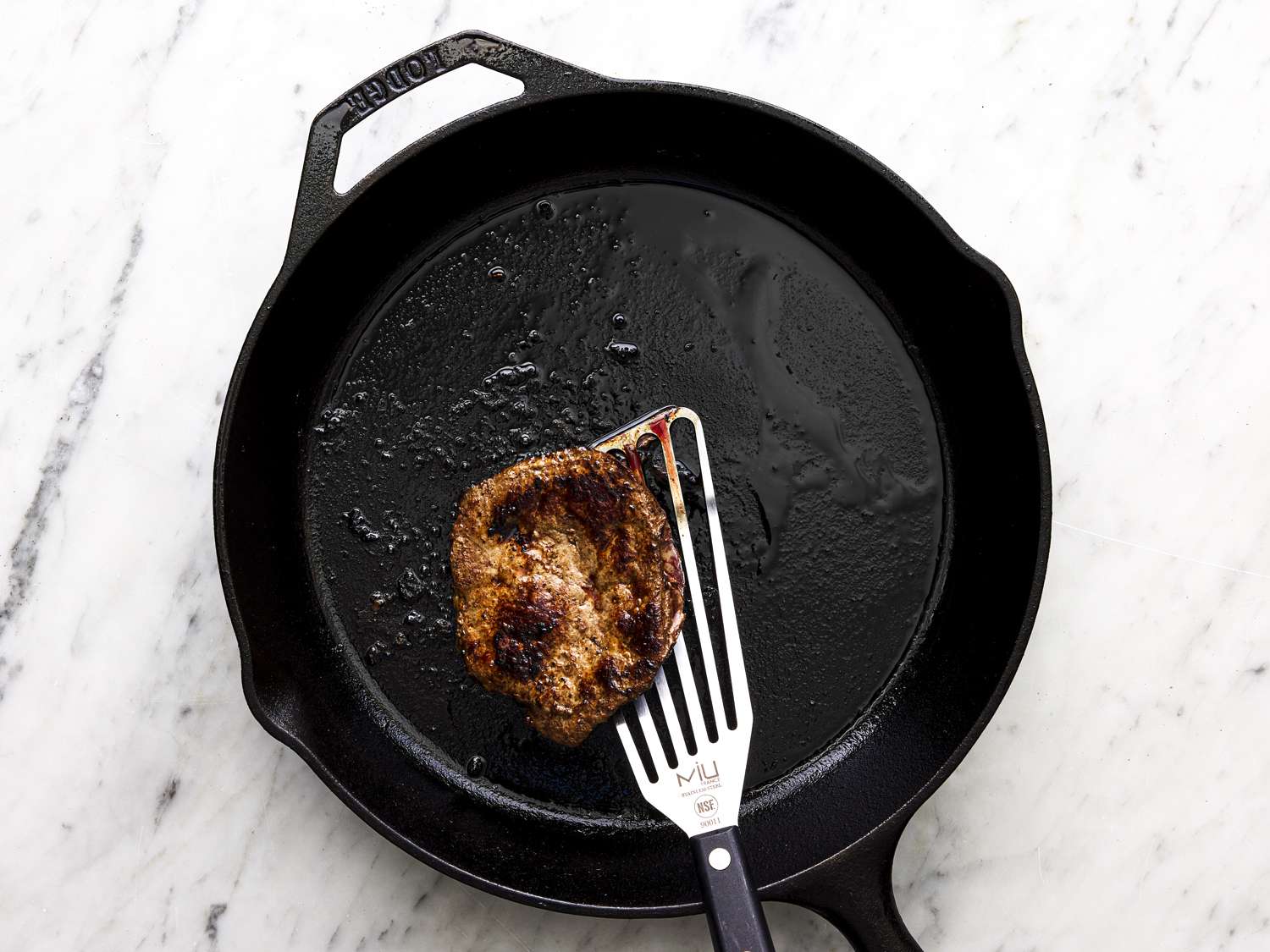 Overhead view of liver cooking in a cast iron skillet