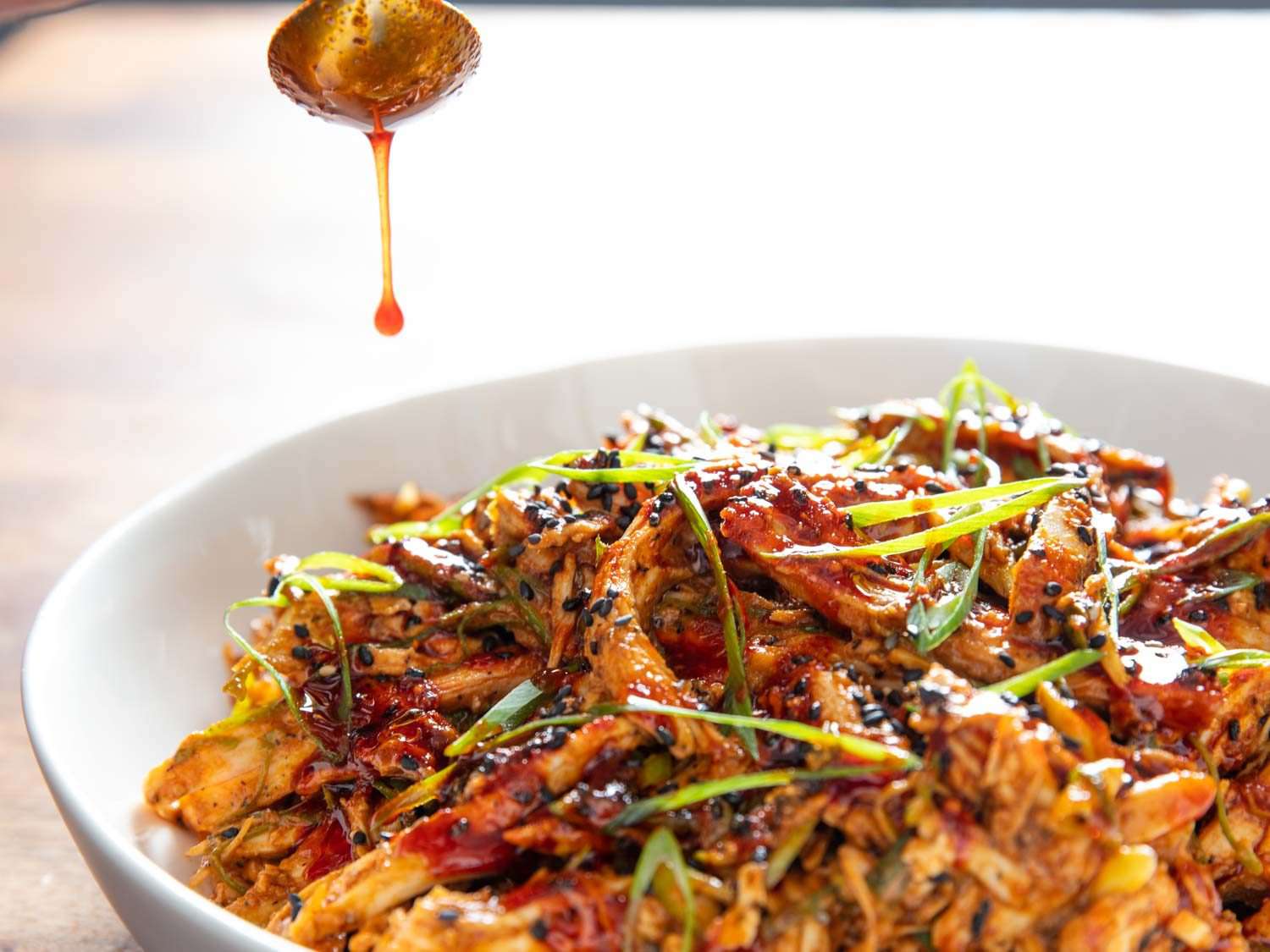 Drizzling extra chili oil over a bowl of Bang Bang Turkey.