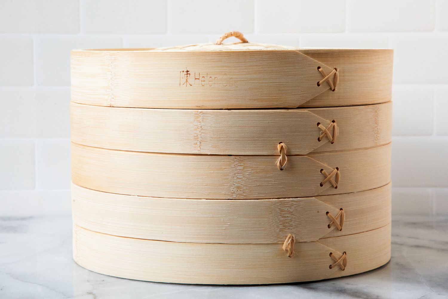 helens asian kitchen bamboo steamer on marble surface with white tile backdrop