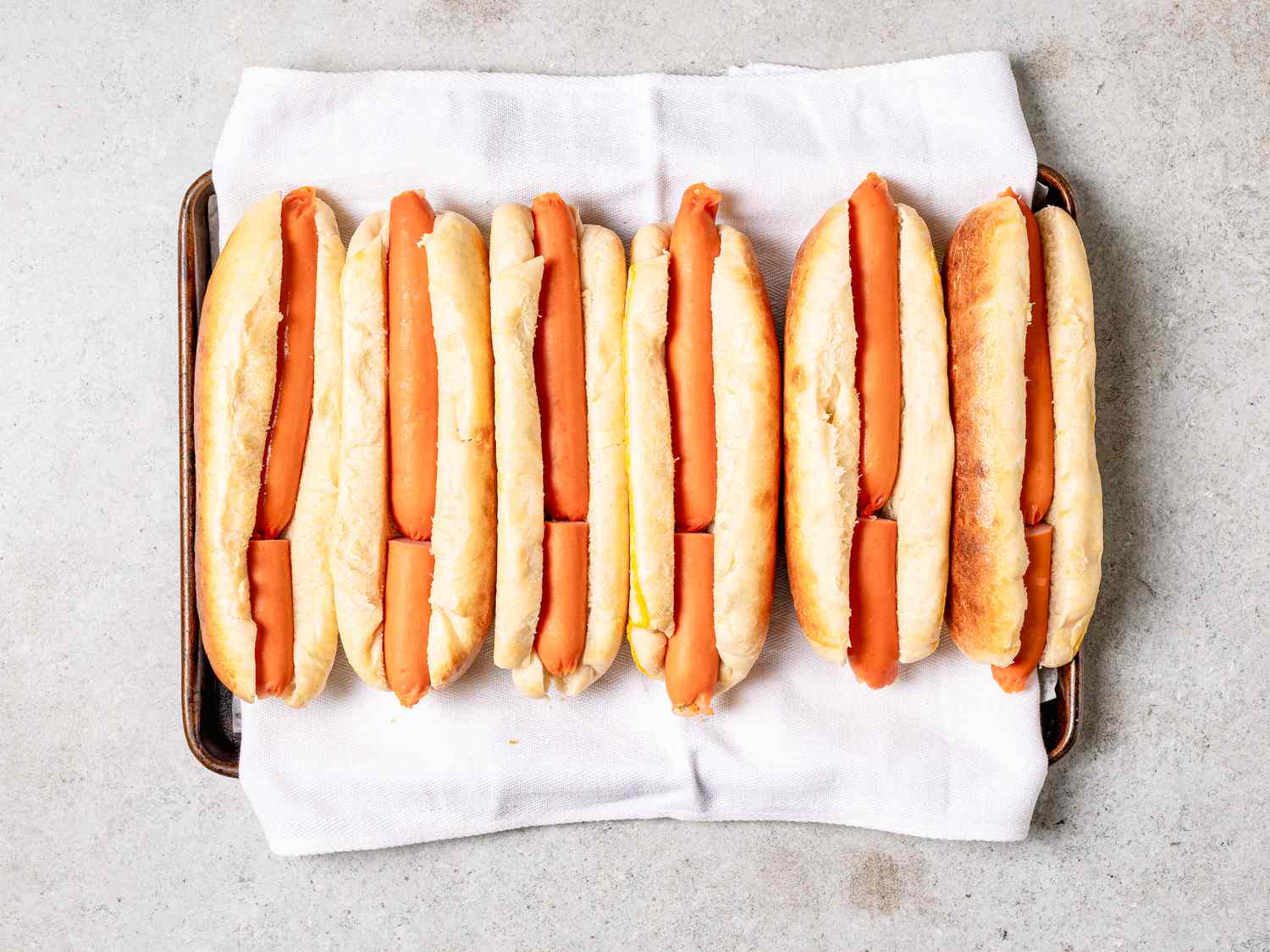 Overhead view of adding hot dogs to buns