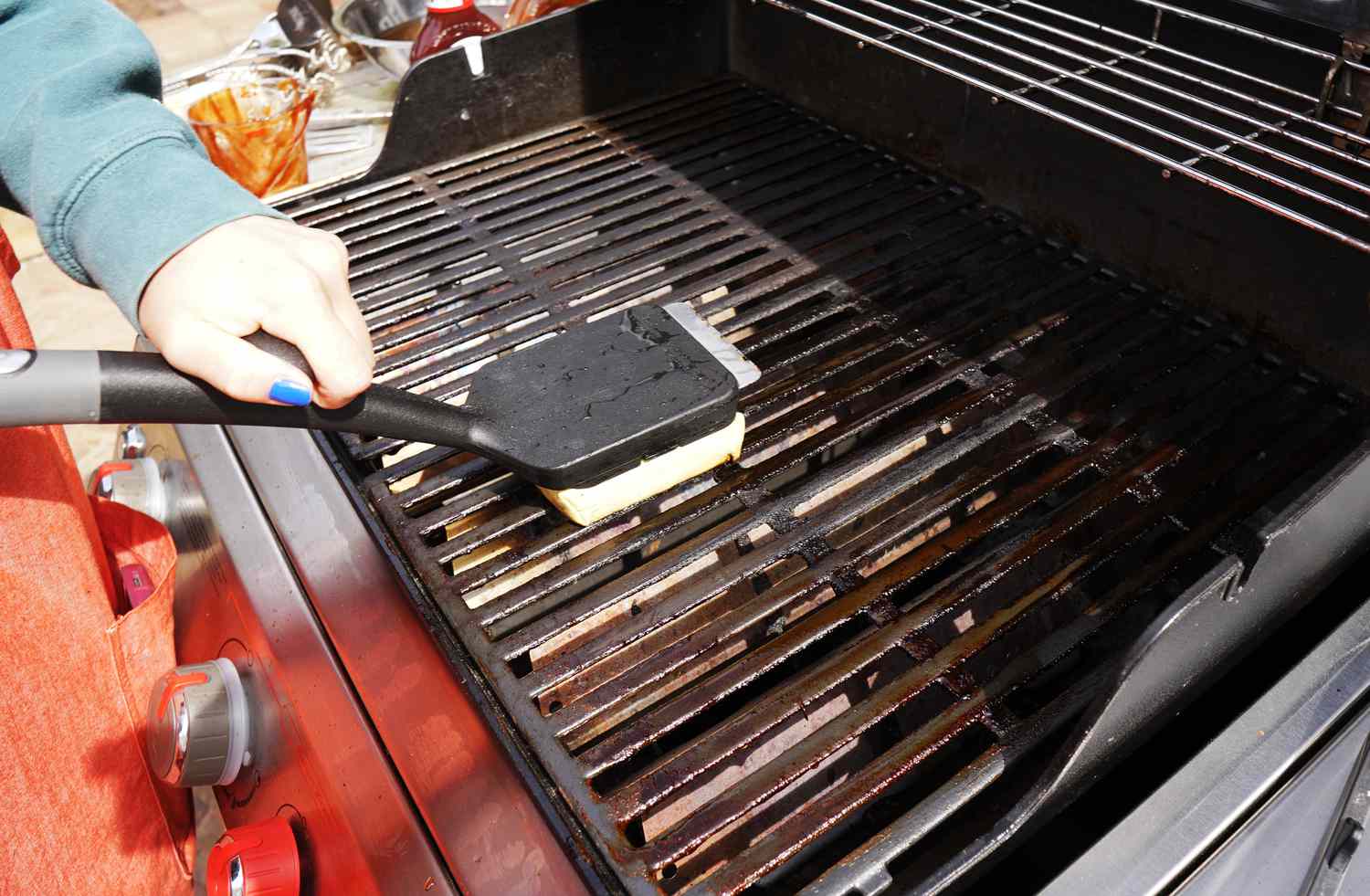 a person using a grill brush to clean a grill