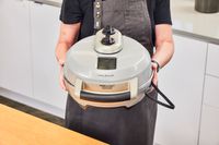 A person holding the Breville pizza maker.