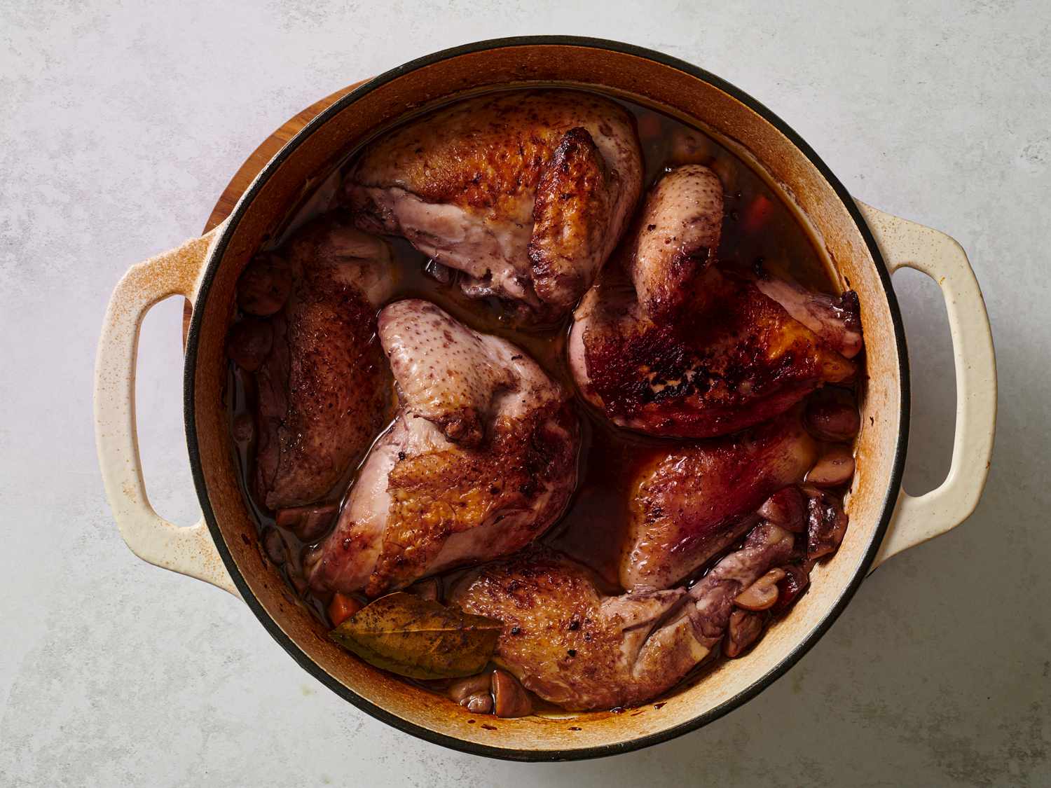 Chicken breasts added to Dutch oven, nestled, skin side up, amongst the legs.