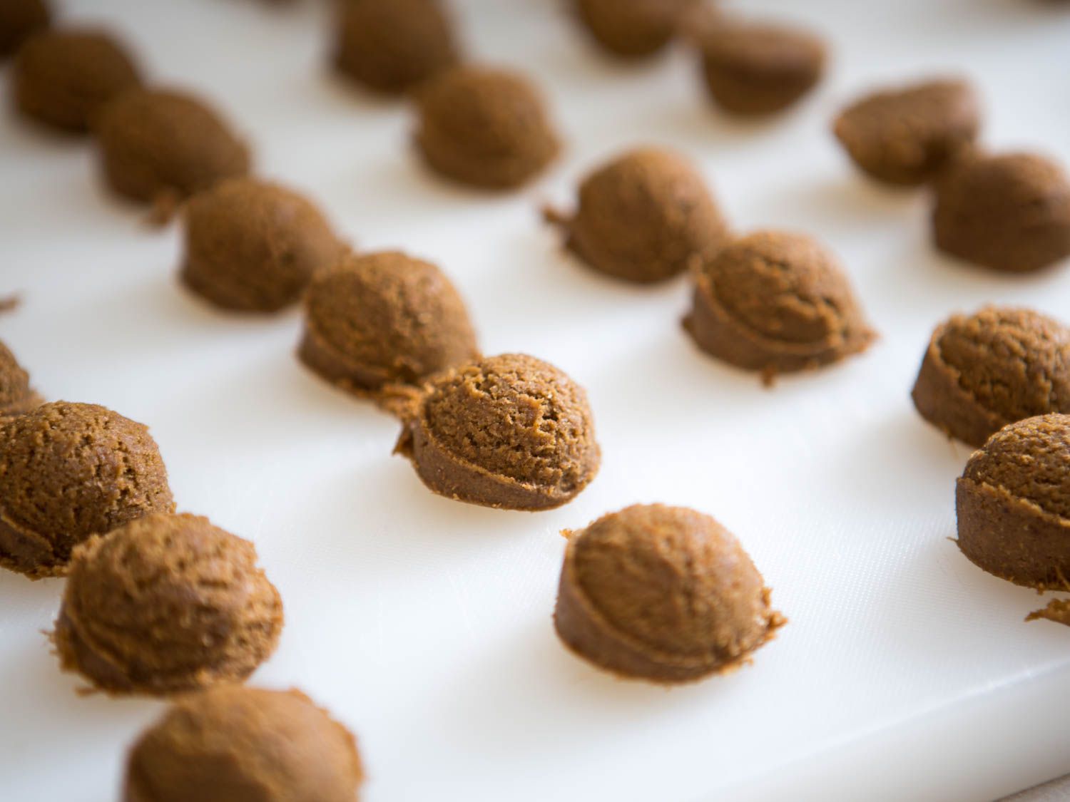 Portioned gingersnap dough on a white work surface. 