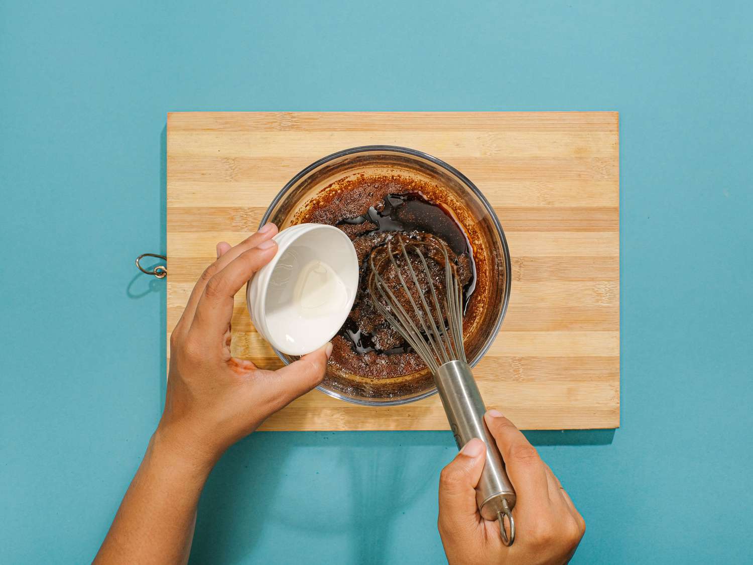 Mixing melted coconut oil into large bowl with other ingredients. 